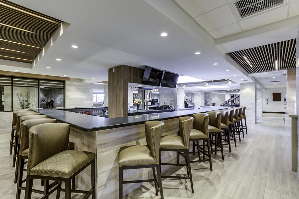 A modern bar interior with a sleek counter and comfortable seating.