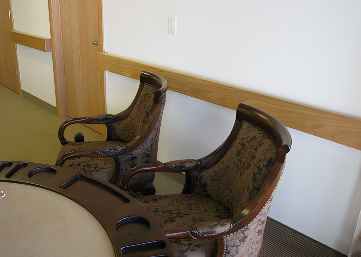 A pair of antique wooden chairs with ornate design in a room.
