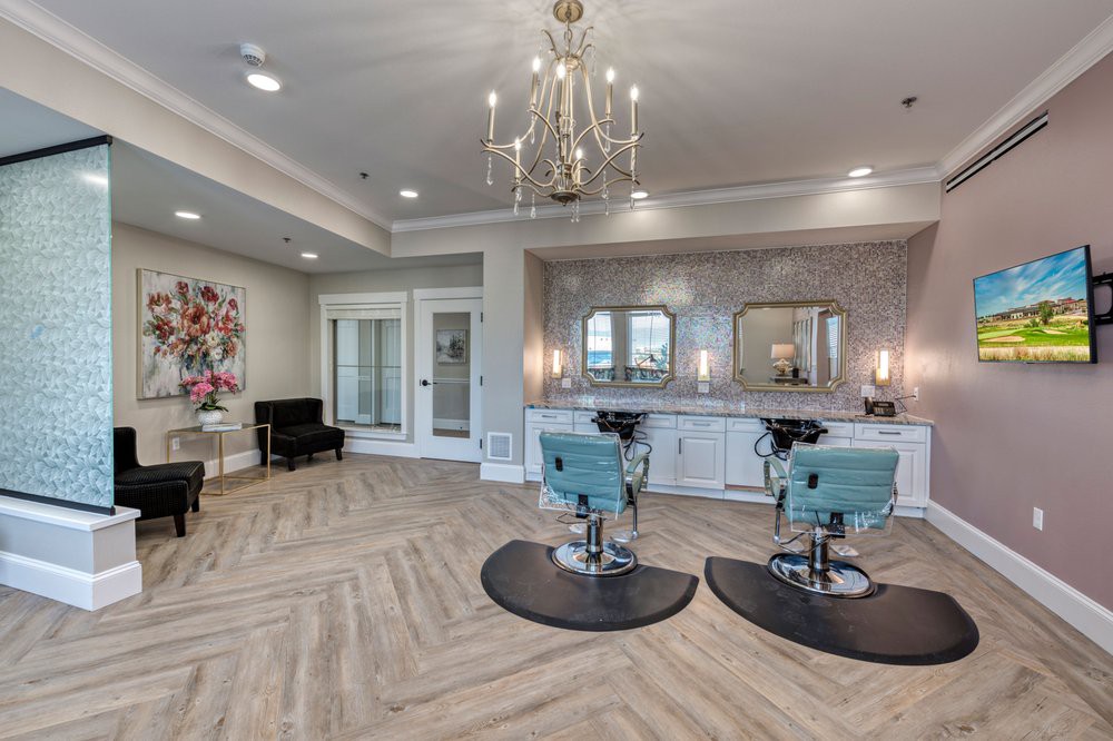 A modern beauty salon with elegant chandeliers and stylish seating.