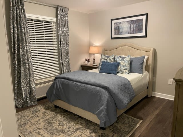 A cozy bedroom with a neatly made bed, elegant decor, and soft lighting.