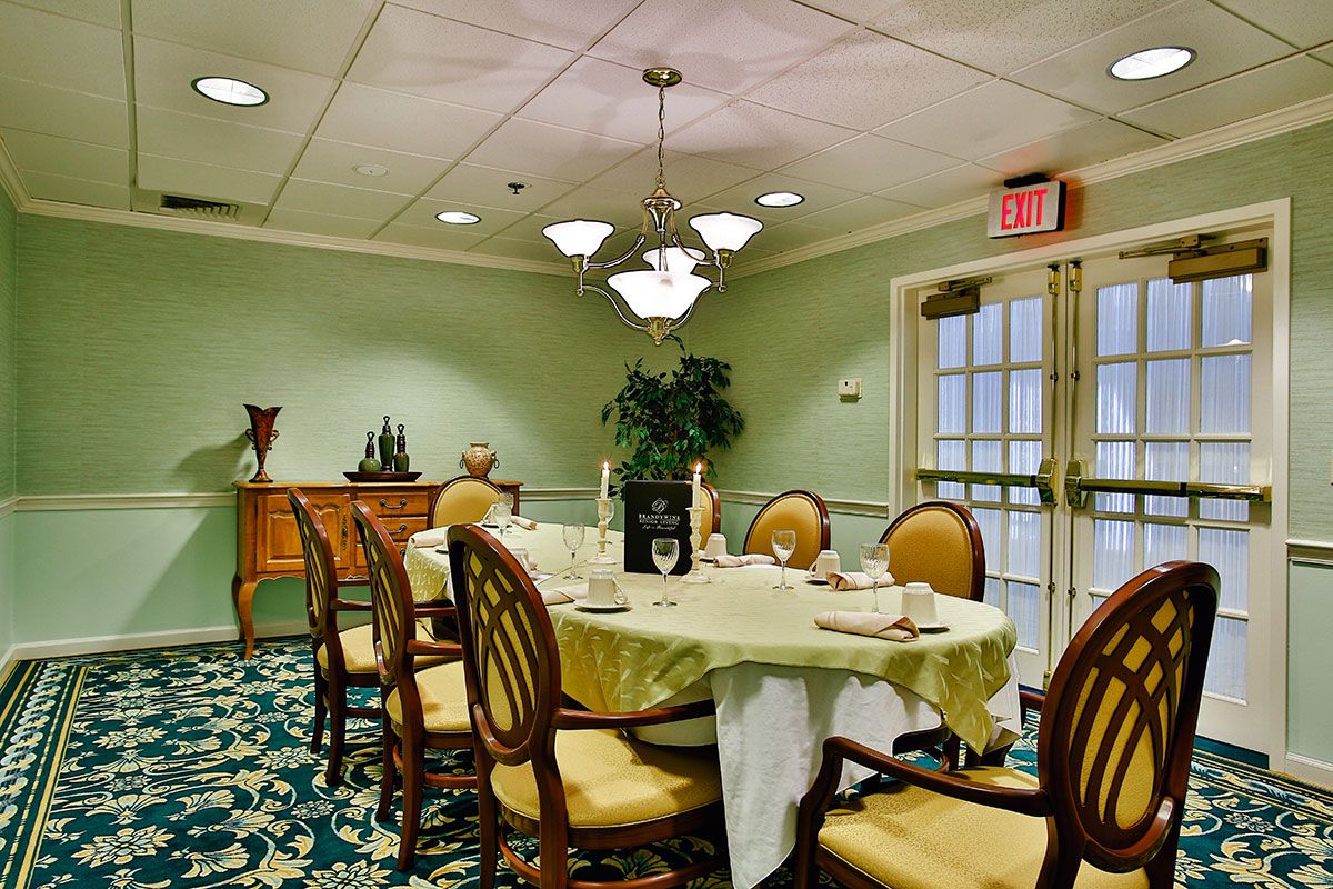 An elegantly decorated dining room with a set table and chandelier lighting.