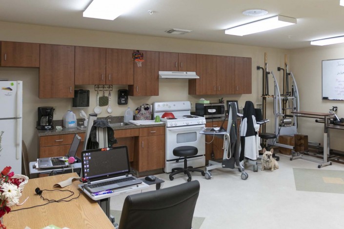 A veterinary clinic with a mix of medical and office equipment, including a computer and kitchen area.