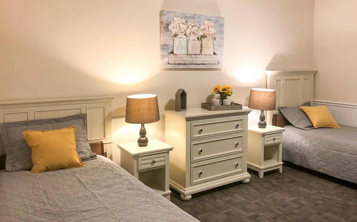 A cozy bedroom with matching furniture and warm lighting.