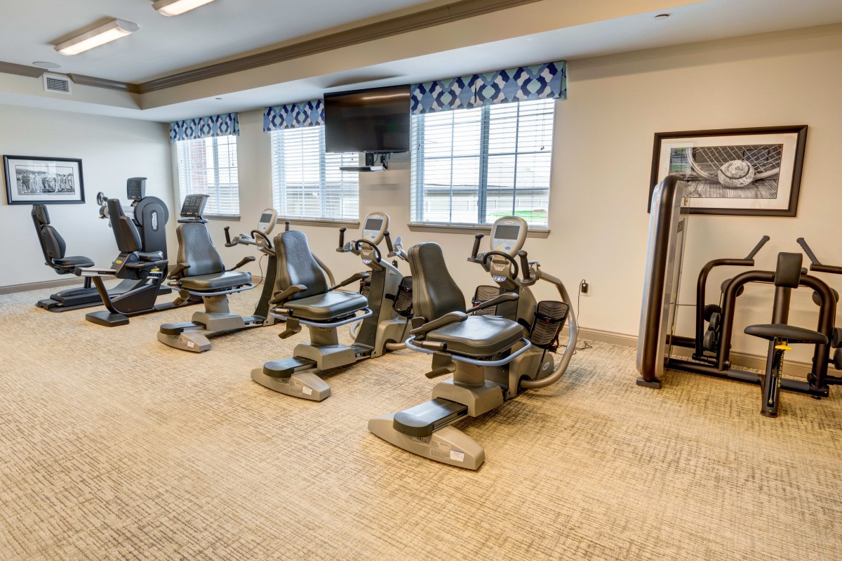A well-equipped gym with various cardio machines.