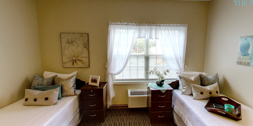 A cozy shared bedroom featuring two beds, warm lighting, and soft curtains.