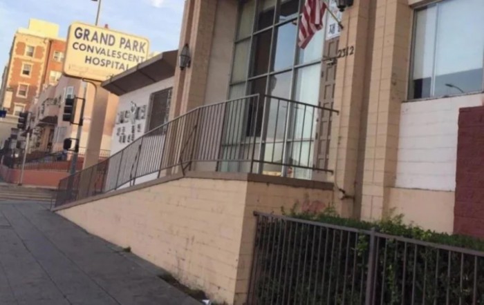 An urban building with a ramp, American flag, and visible signage.