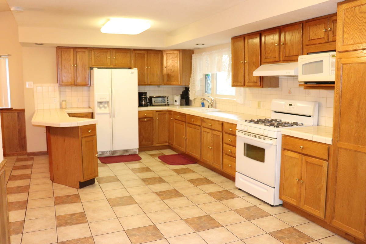 Spacious kitchen with wooden cabinets and modern appliances.