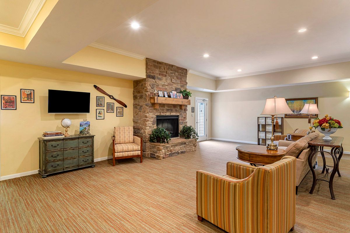 A cozy living room with a stone fireplace and modern decor.