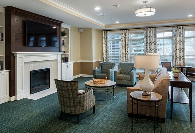 A cozy living room with comfortable seating, a fireplace, and a wall-mounted TV.