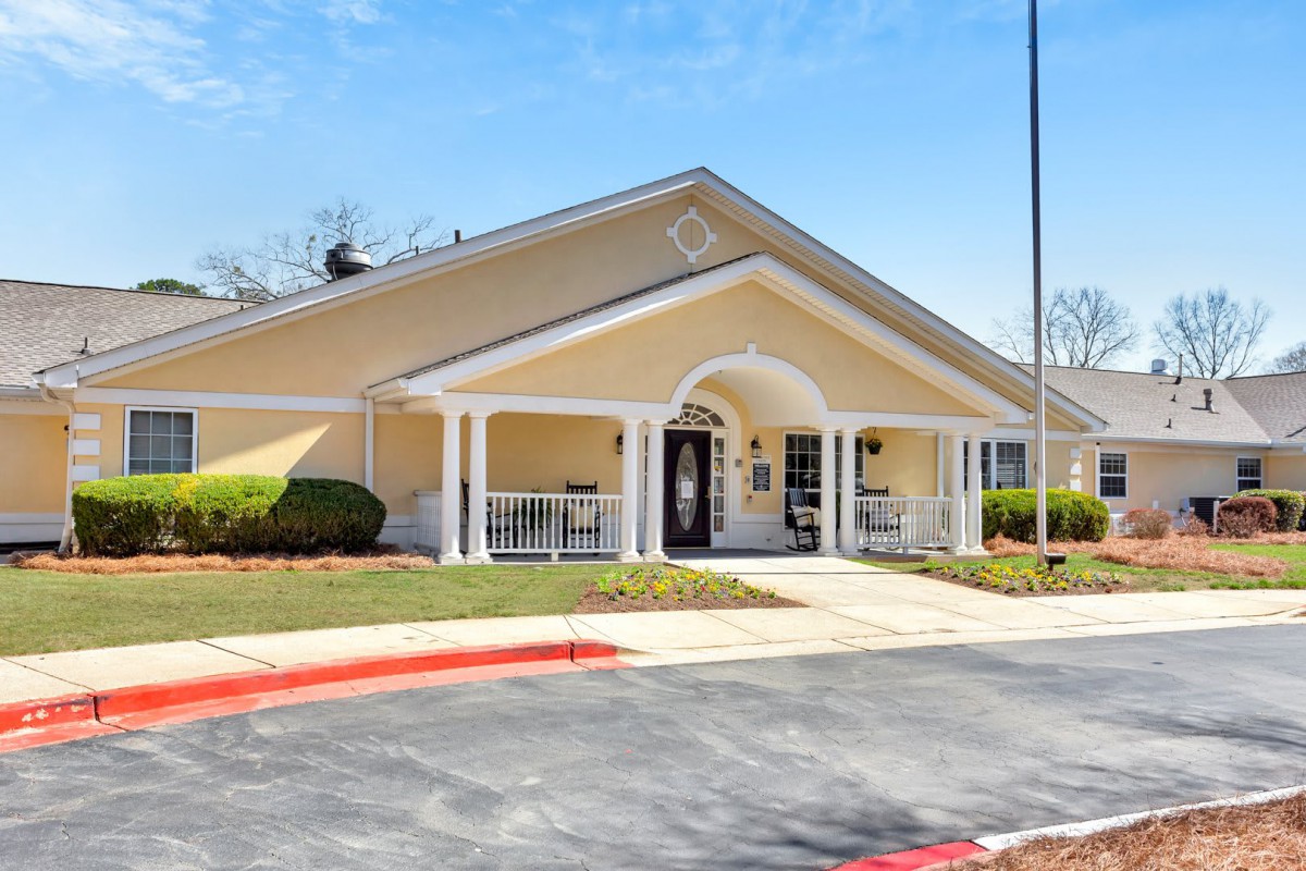 A single-story residential building with a front porch and driveway.