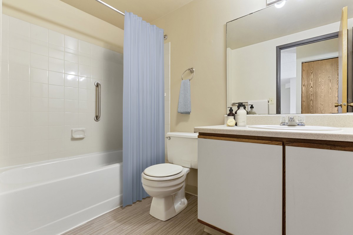 A modern bathroom with a shower, toilet, and sink.