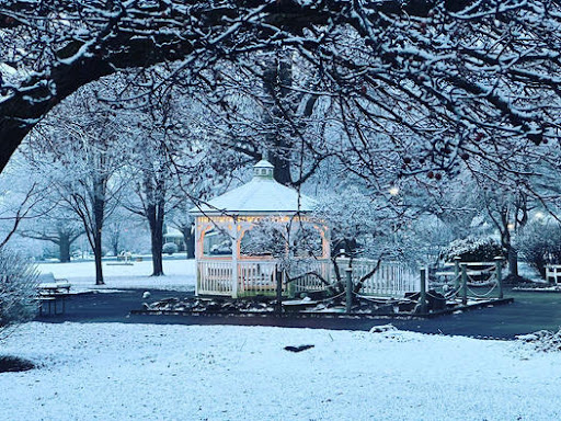 A serene winter scene with a gazebo surrounded by freshly fallen snow.