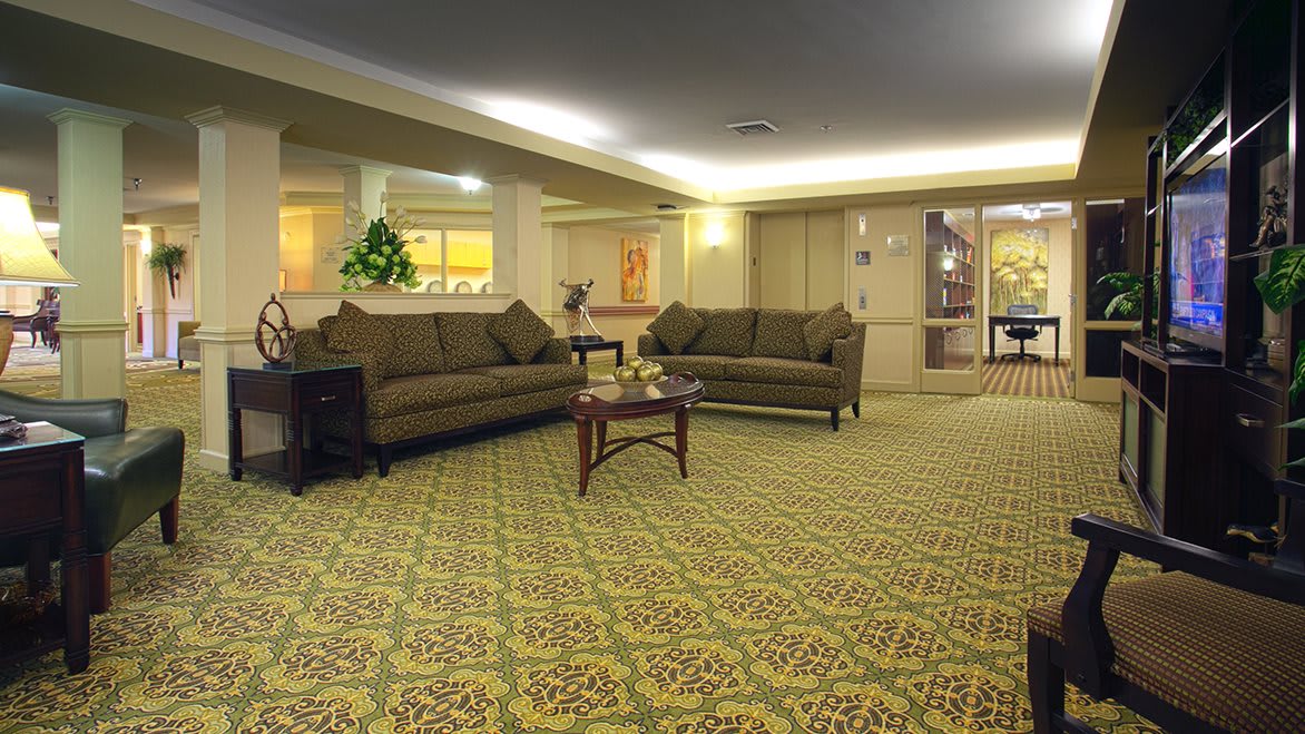 A spacious lobby with comfortable sofas and a patterned carpet.