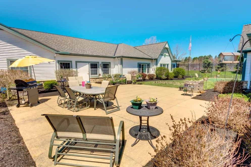 A sunny backyard patio with various outdoor furniture and well-maintained landscaping.