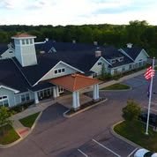 Aerial view of a building with a parking lot and a flagpole in front.