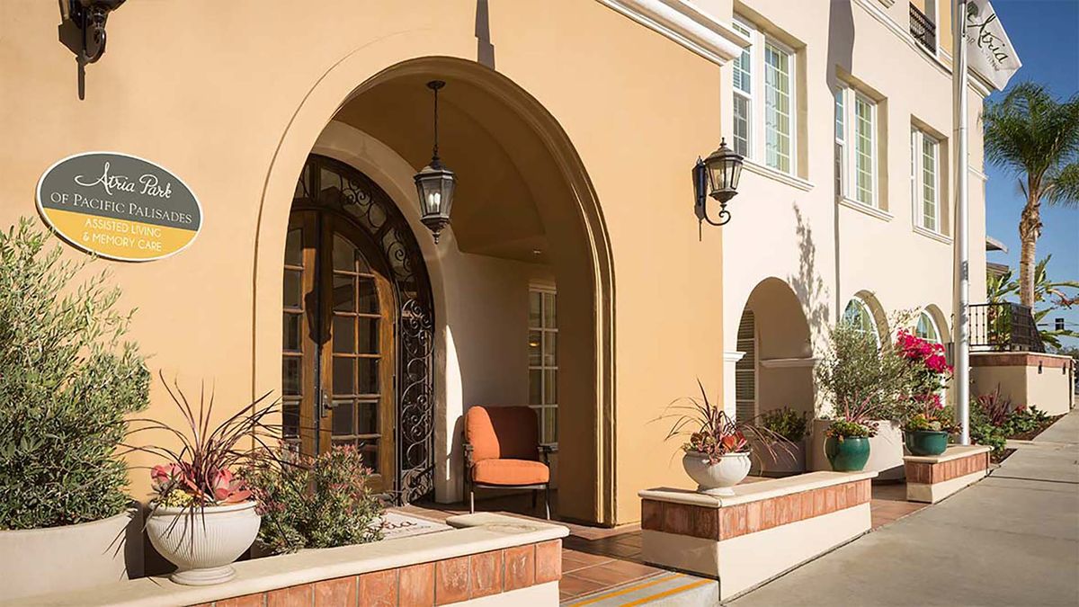 A Mediterranean-style entrance with archways, featuring outdoor seating and decorative lanterns.