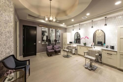 A modern salon interior with styling chairs and mirrors, featuring elegant lighting.