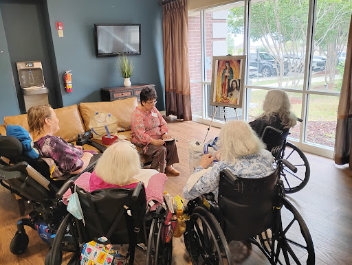 A group of seniors engaging in a social activity at a community center, surrounded by artwork and enjoying each other's company.