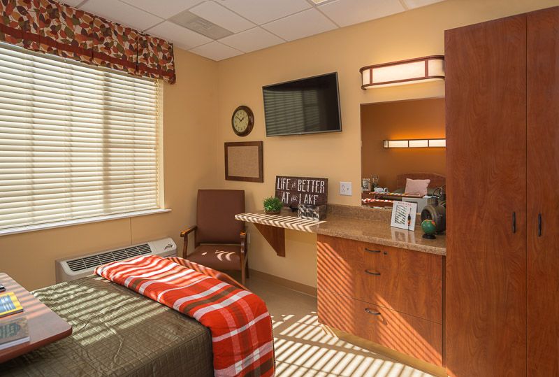 A cozy and well-decorated bedroom with modern amenities, including a mounted television and stylish furnishings.