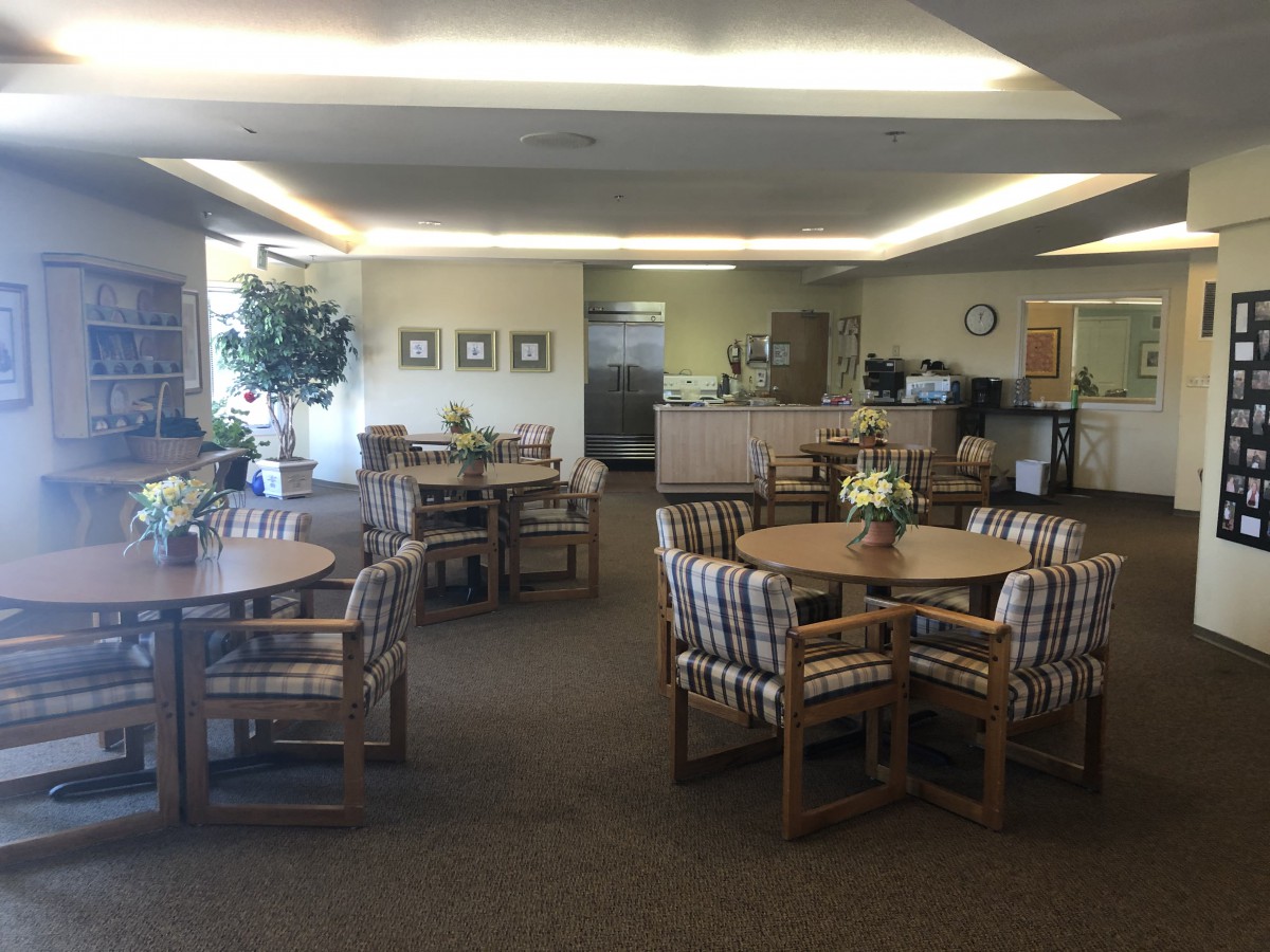 A spacious and well-lit lounge area with tables and chairs arranged for casual meetings or relaxation.