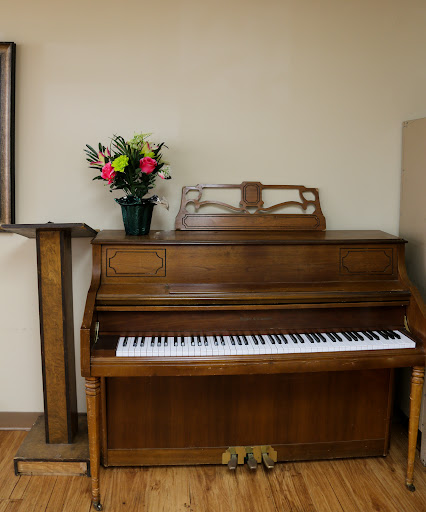 A wooden piano accompanied by a vibrant bouquet of flowers, adding charm to the interior.