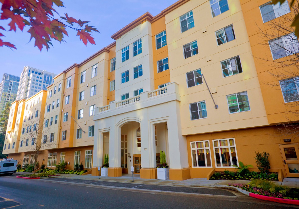 A multi-story residential apartment building with a symmetrical facade and large windows.