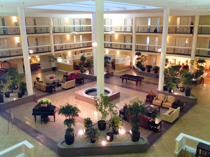 Spacious hotel lobby with a central fountain and seating area.