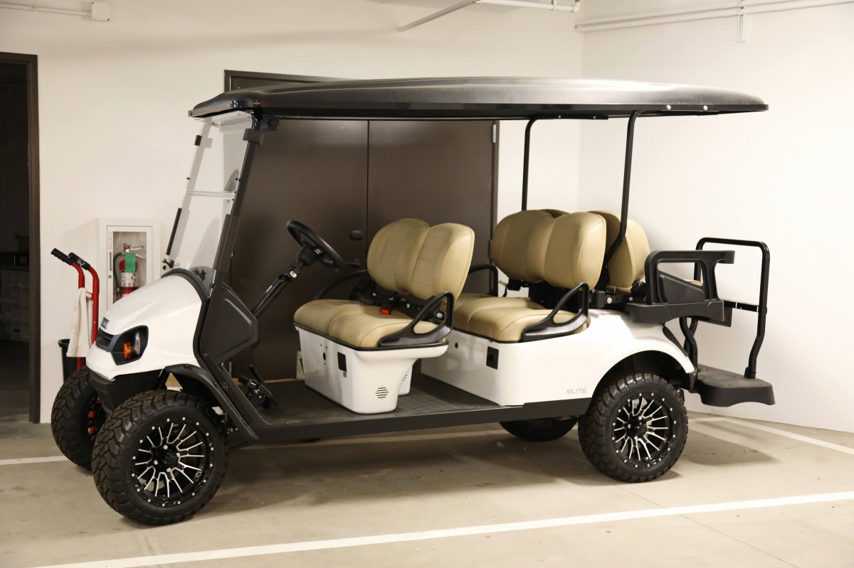 A golf cart with beige seats parked in a garage.