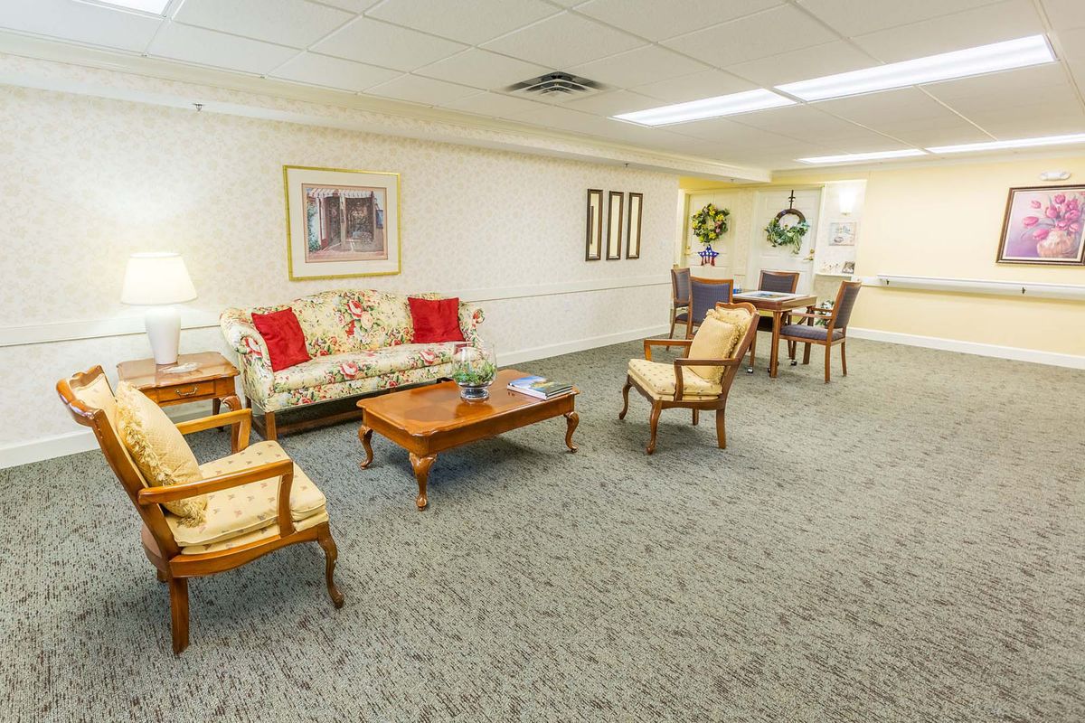 A cozy living room with a sofa, chairs, and a coffee table on a carpeted floor.