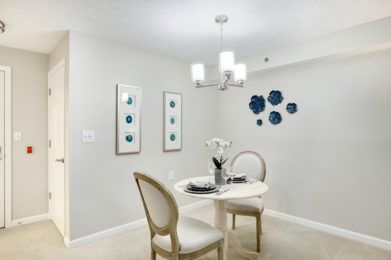 A modern dining room with elegant furniture and decorative wall art.