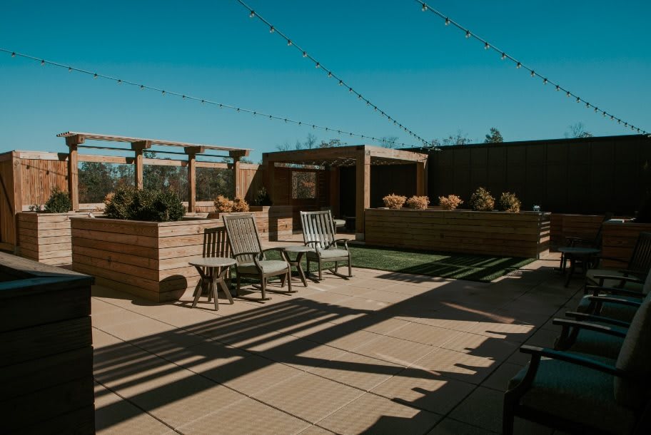 A stylish rooftop patio featuring comfortable seating and ambient string lighting.