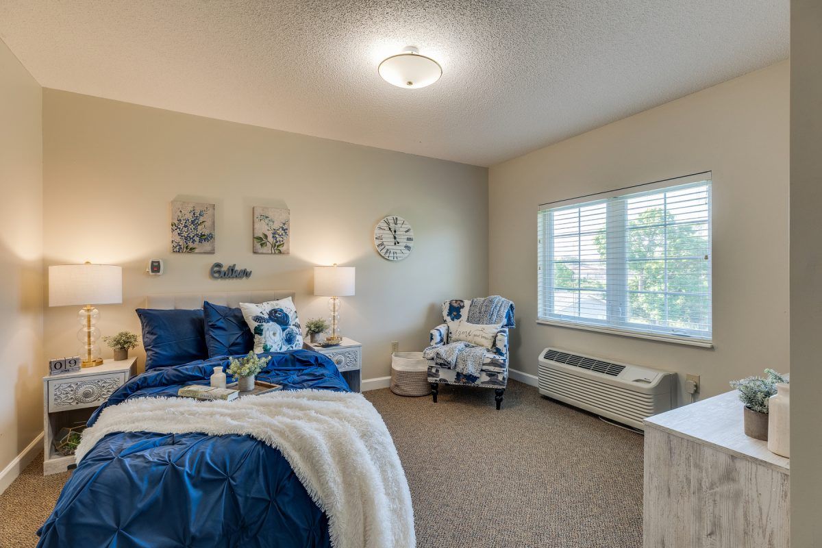 A cozy and well-decorated bedroom with a blue and white color scheme.