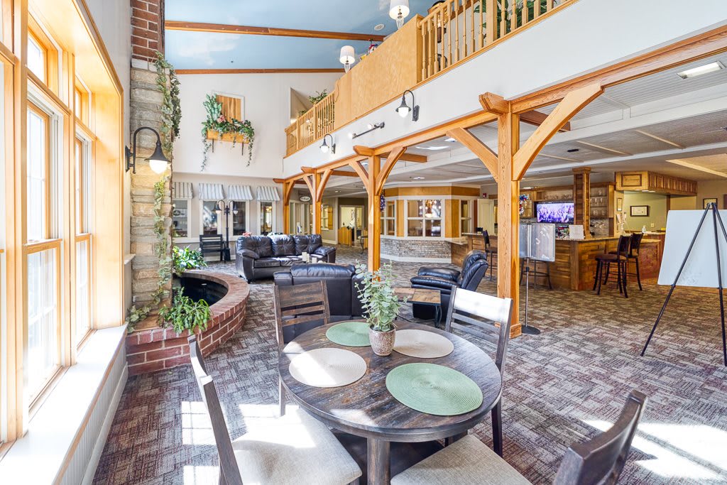 A spacious lobby featuring comfortable seating, wooden beams, and ample natural light.