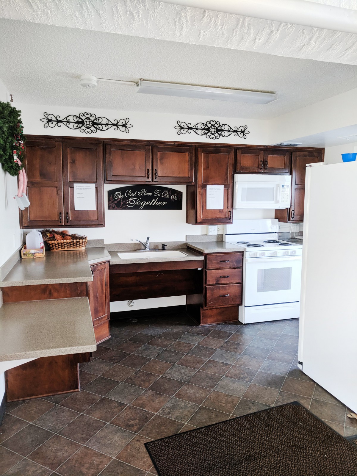 A cozy kitchen with wooden cabinets, a stove, and a sink.