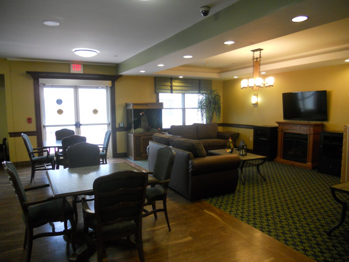 A cozy lobby area with sofas, a television, and seating arrangements.