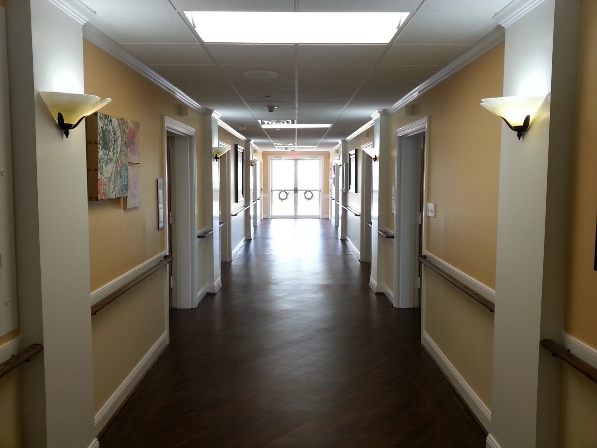 A well-lit indoor hallway with doors on both sides.