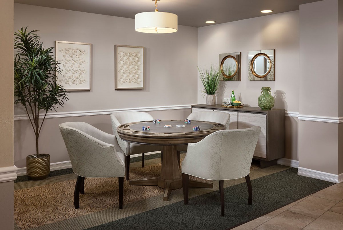 A cozy dining space featuring a round table surrounded by upholstered chairs, complemented by minimalist decor and wall art.