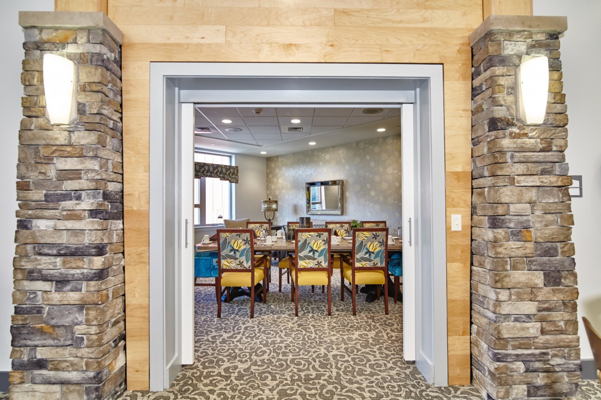 A modern conference room with a large table and upholstered chairs, featuring elegant lighting and decor.
