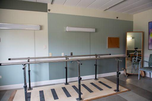 A physical therapy room equipped with walking bars for rehabilitation exercises.