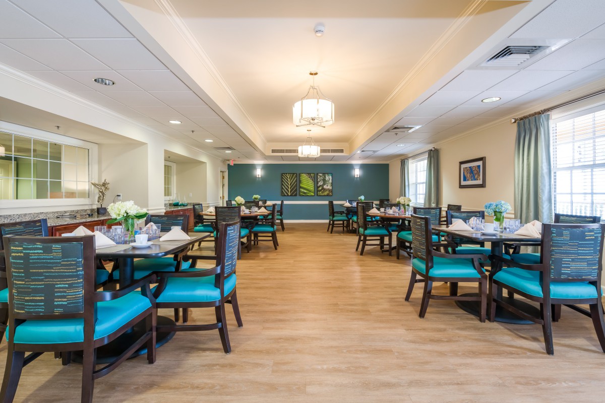 A spacious and elegantly decorated dining area with neatly arranged tables and chairs.