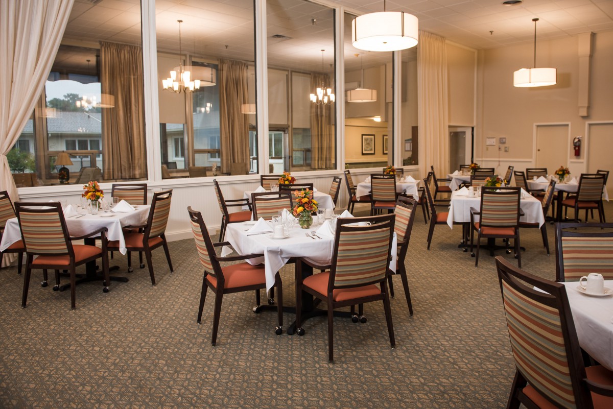 A cozy and elegant dining room setup with neatly arranged tables and chairs.