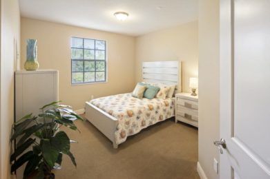 Cozy bedroom with a bed, nightstand, and window view.