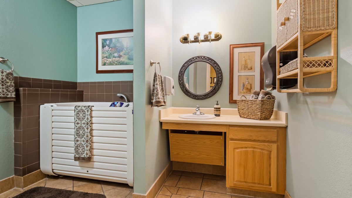 A cozy bathroom featuring a sink, mirror, and laundry area with a washer.