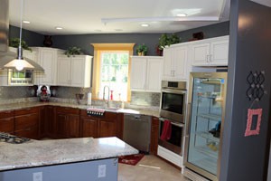 A modern kitchen with sleek appliances and white cabinets.