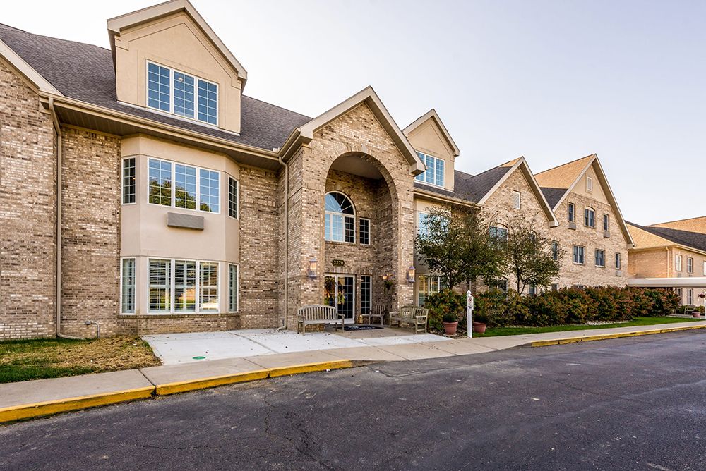 A stone facade residential building with a prominent entrance and multiple windows.