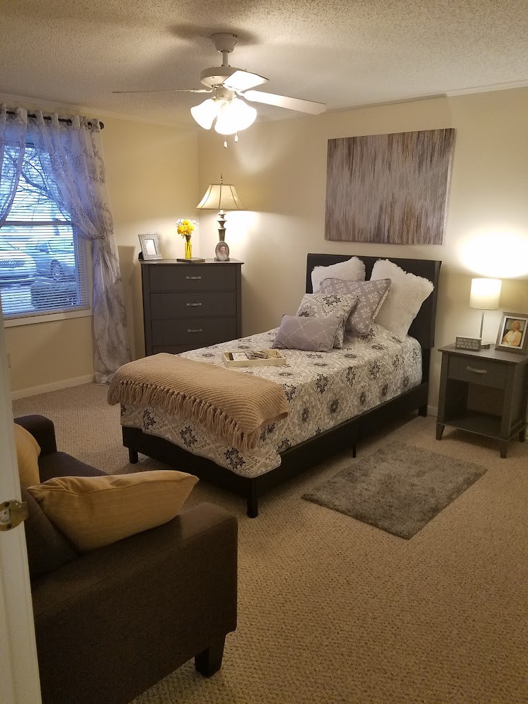 A cozy bedroom with a neatly arranged bed, soft lighting, and elegant decor.