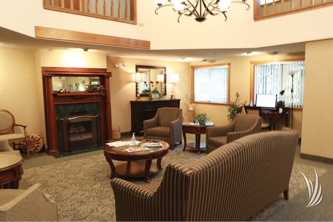 A cozy living room with a classic fireplace, comfortable seating, and elegant lighting.
