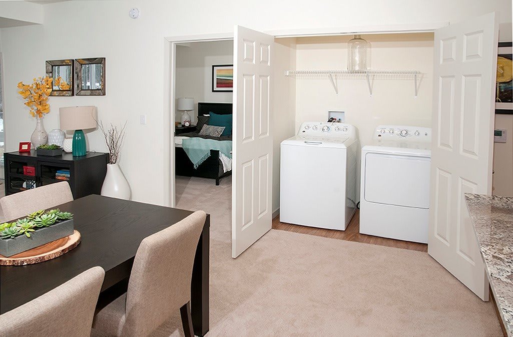 An interior view of a home with a dining area and a laundry space containing a washer and dryer.
