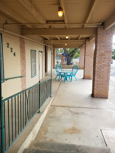 A view of the outdoor patio area with turquoise furniture outside a residential building.