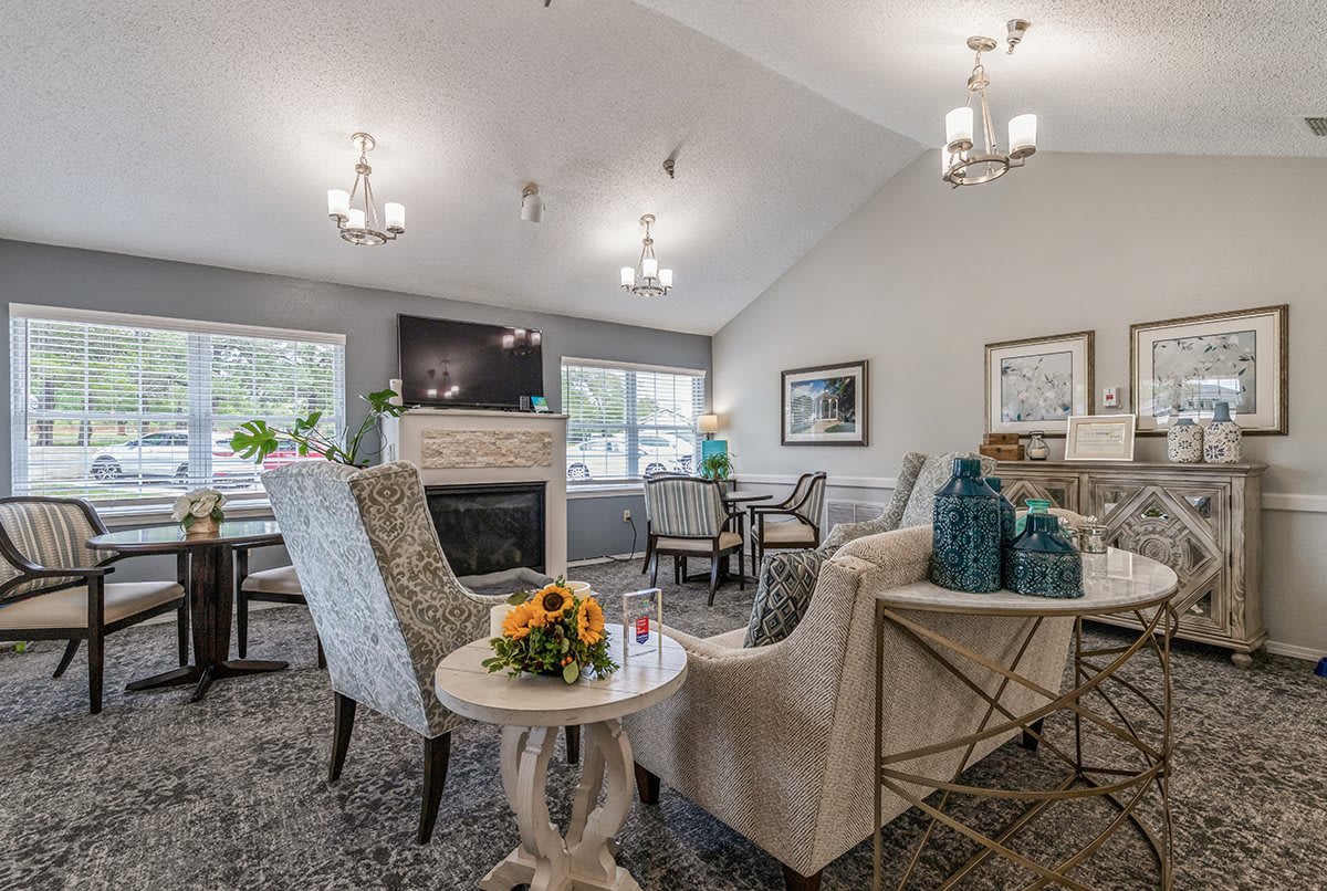 A cozy and elegantly designed living room with a fireplace, modern furniture, and stylish chandeliers.